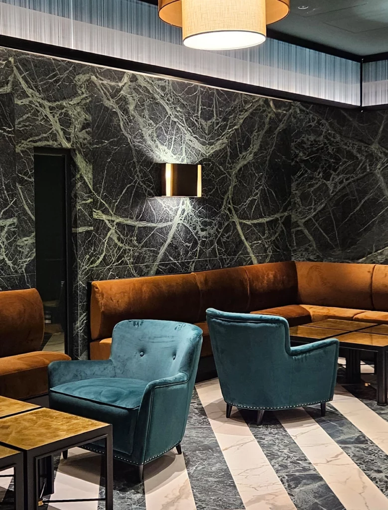 Lounge Hilton Rome EUR La Lama con rivestimenti in marmo e arredi tailor-made blu