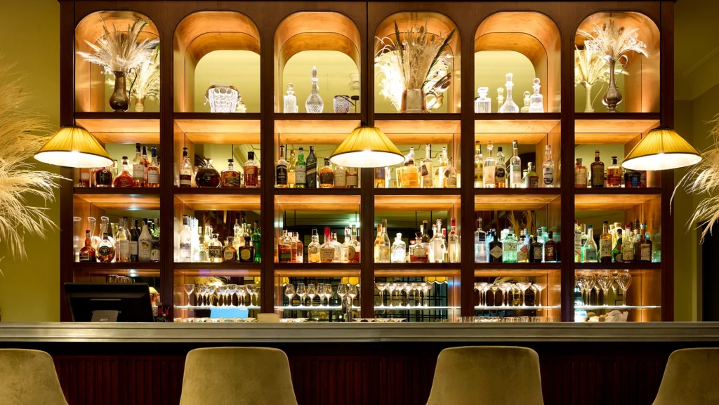 Retro bar con scaffalatura in legno illuminata e arredi su misura al ristorante Il Clementino Roma, progetto luxury & lifestyle Antonacci Falegnamerie