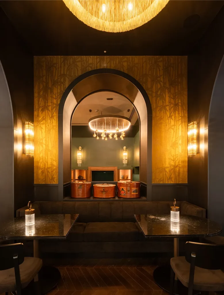 Nicchia con divanetto scuro, parete dorata decorativa e lampadario circolare in stile contemporaneo