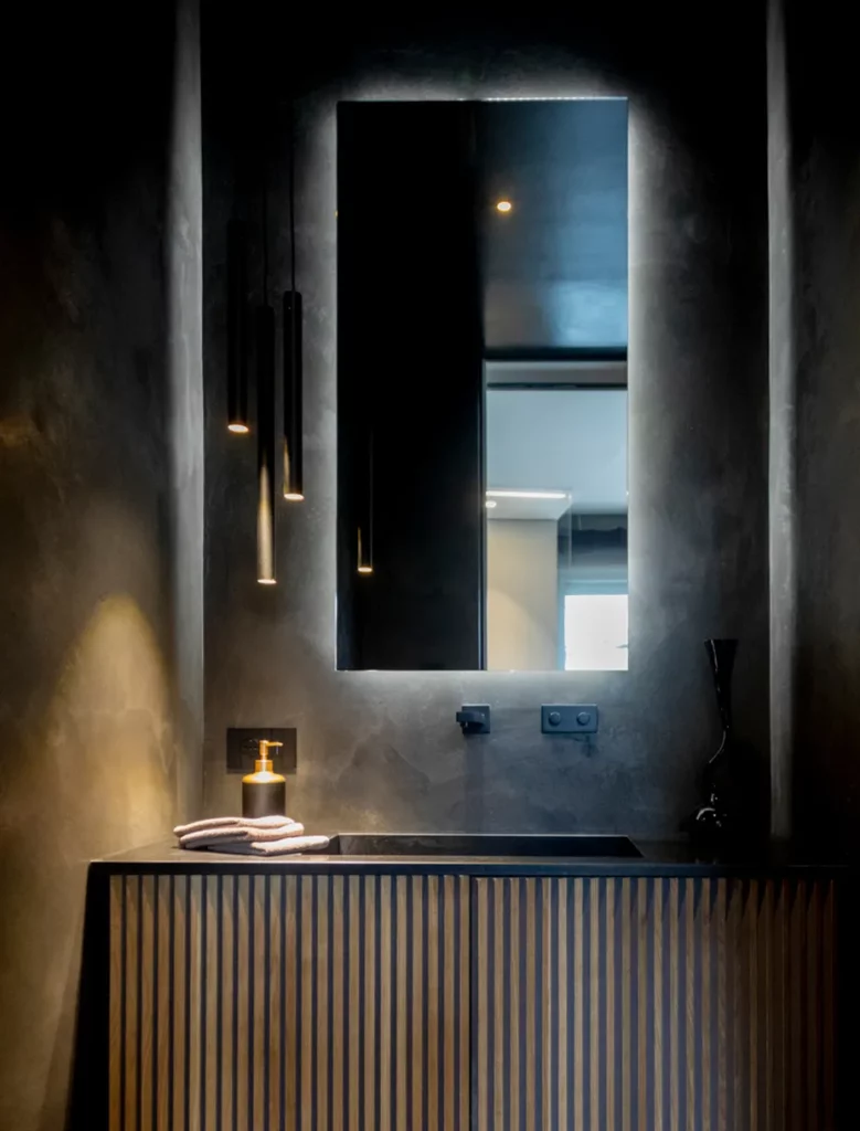 Bagno contemporaneo con rivestimenti scuri e mobile lavabo in legno scanalato