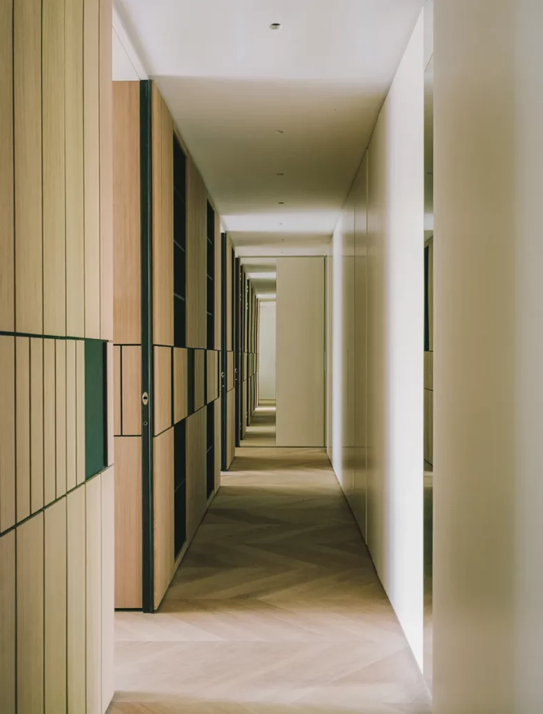 Corridoio con boiserie e armadi a muro in legno su misura realizzati da Antonacci falegnamerie, pavimento in legno a spina di pesce