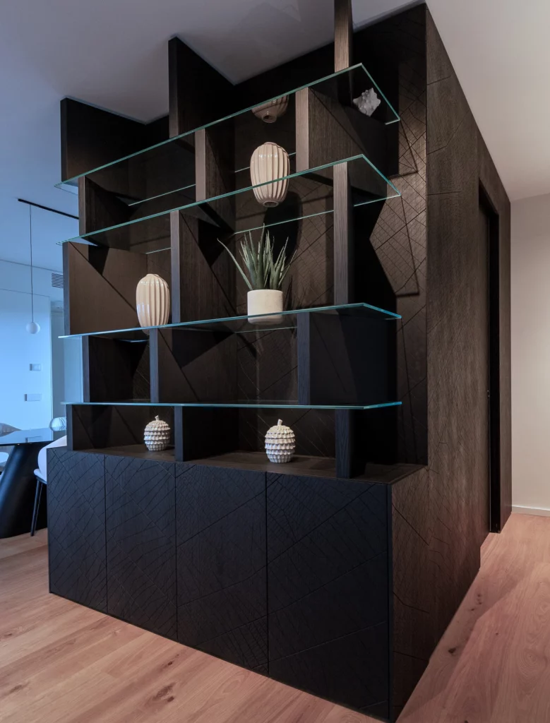 libreria in legno scuro con ripiani in vetro e oggetti decorativi, falegnameria artigianale Antonacci progetto residenziale