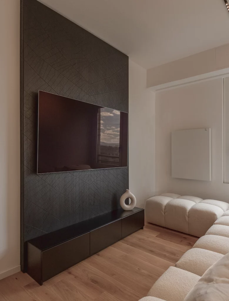 boiserie scura con TV integrata e divano chiaro con cuscini, progetto residenziale antonacci falegnamerie